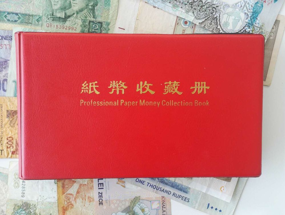 描述：这是一本红色的纸币收藏册，放在不同的纸币上的特写照片。(本地向导 @TsekoV)
