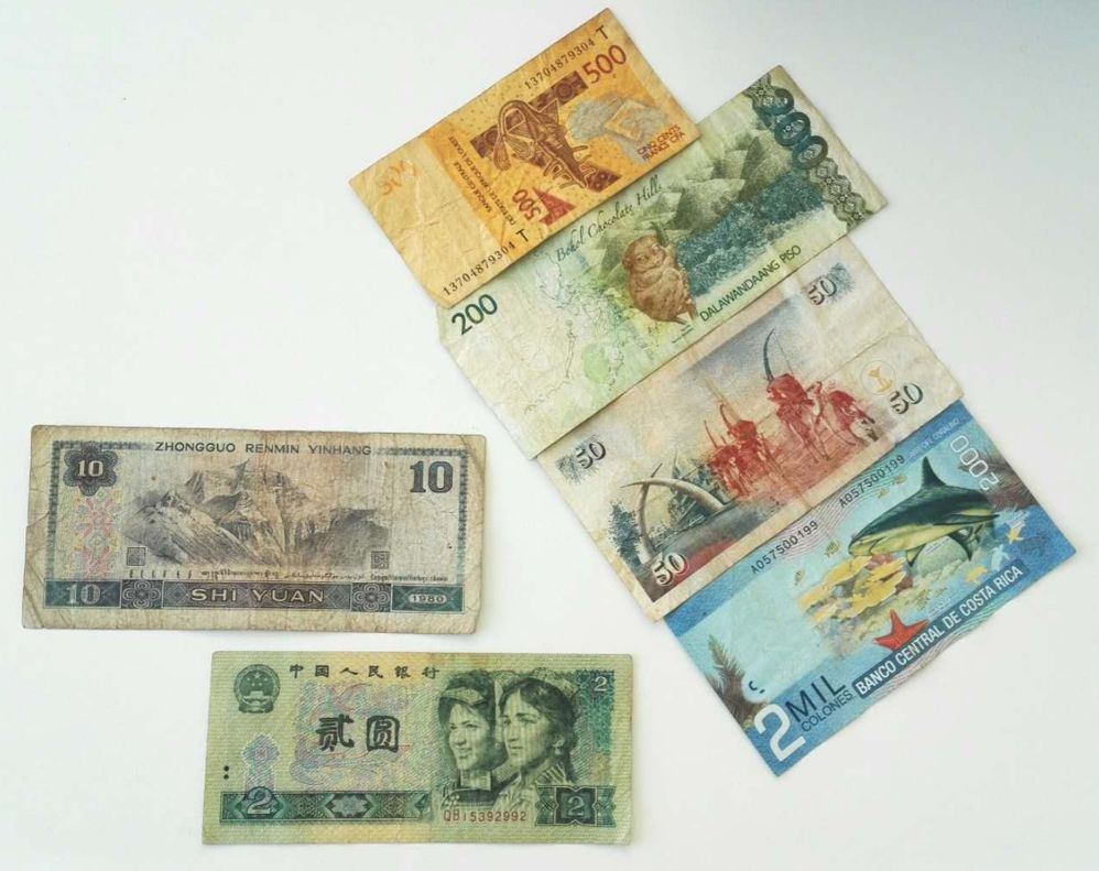 描述：几张不同货币的照片，包括人民币，西非法郎，菲律宾比索，肯尼亚先令和哥斯达黎加科隆。(本地向导 @TsekoV)