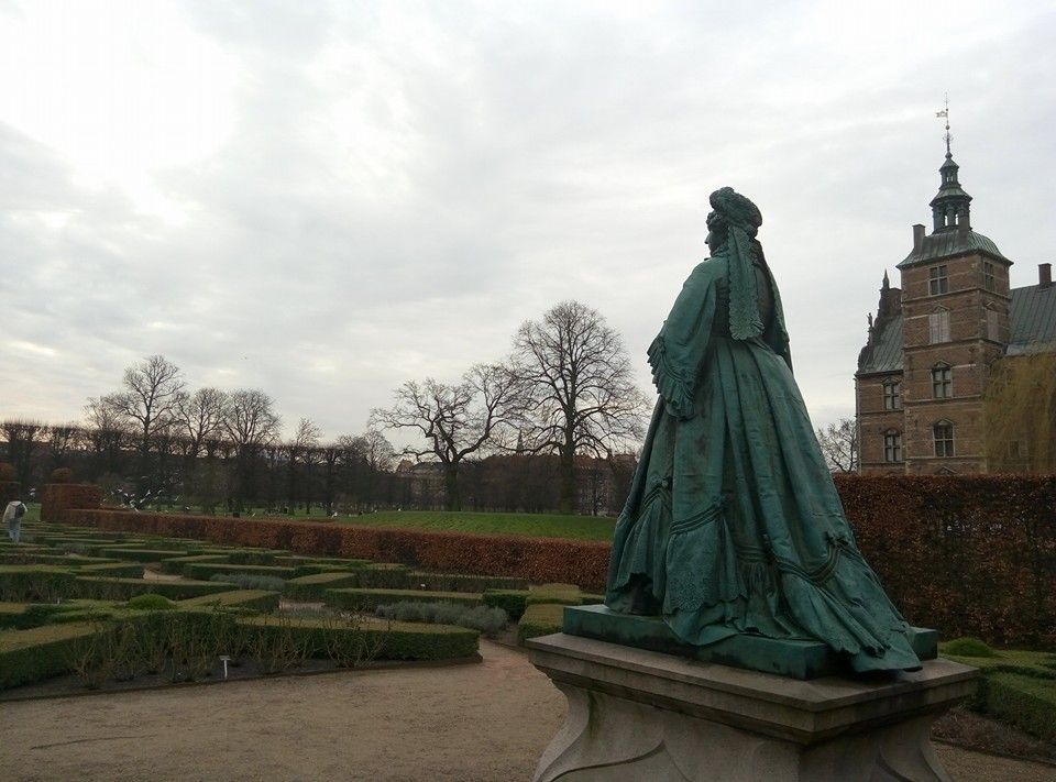 Caption: A photo of a statue of a queen, green labyrinth garden and the Rosenborg castle. (Local Guide @TsekoV)