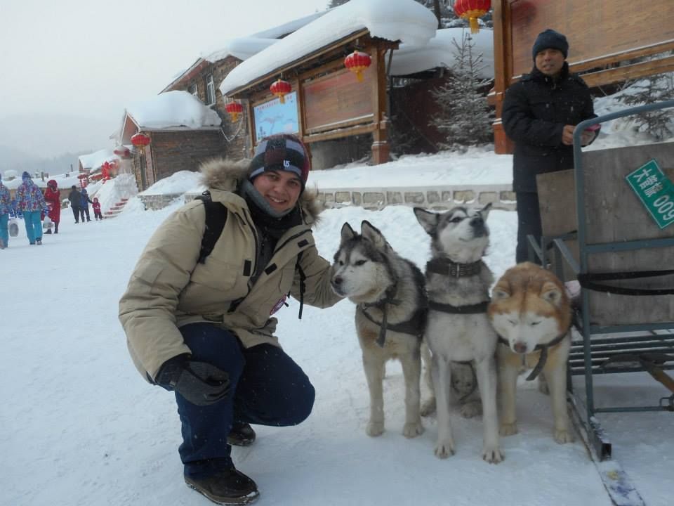 Caption: A photo of me posing with three husky dogs which ride a sleigh in China Snow Town. (Local Guide @TsekoV)