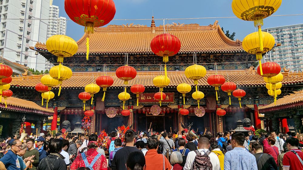 Caption: A photo of a crowd of people in front of the Sik Sik Yuen Wong Tai Sin Temple in Chuk Un, Hong Kong. (Local Guide Vming Yan)