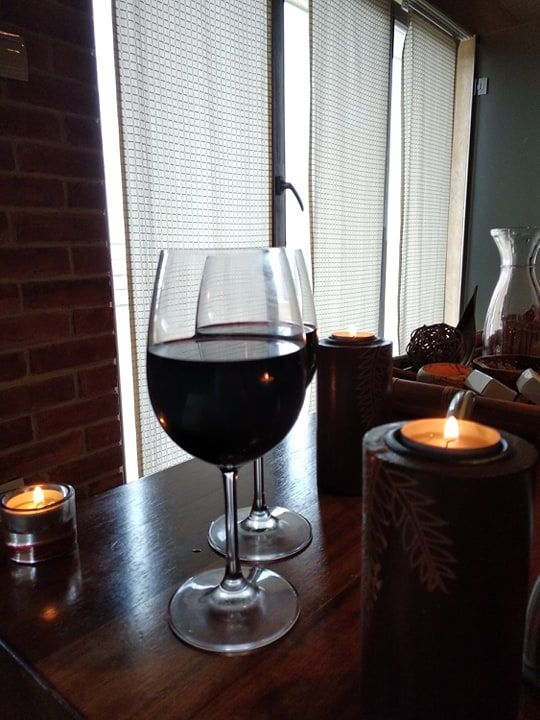 Caption: A photo showing two glasses of red wine and candies on the table. (Local Guide @PoliMC)