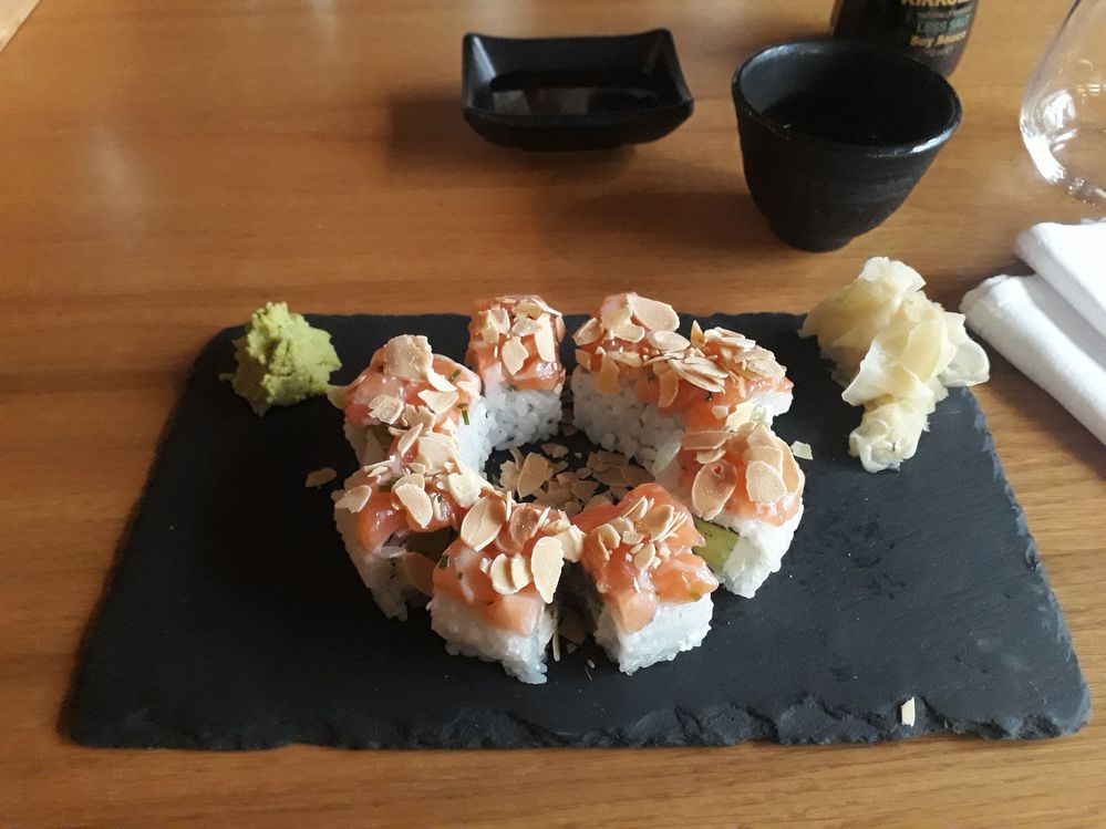 Caption: A photo of sushi arranged in a circle, the pieces are covered with slivered almonds (Local Guide @MoniDi)