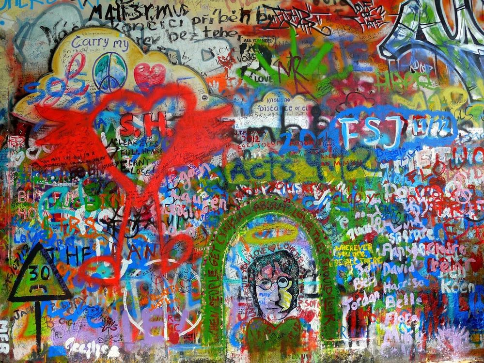Caption: A photo of the Lennon Wall in Prague, an outdoor wall covered in colorful spray painted graffiti in honor of the Beatles’ John Lennon. (Local Guide George Charleston)