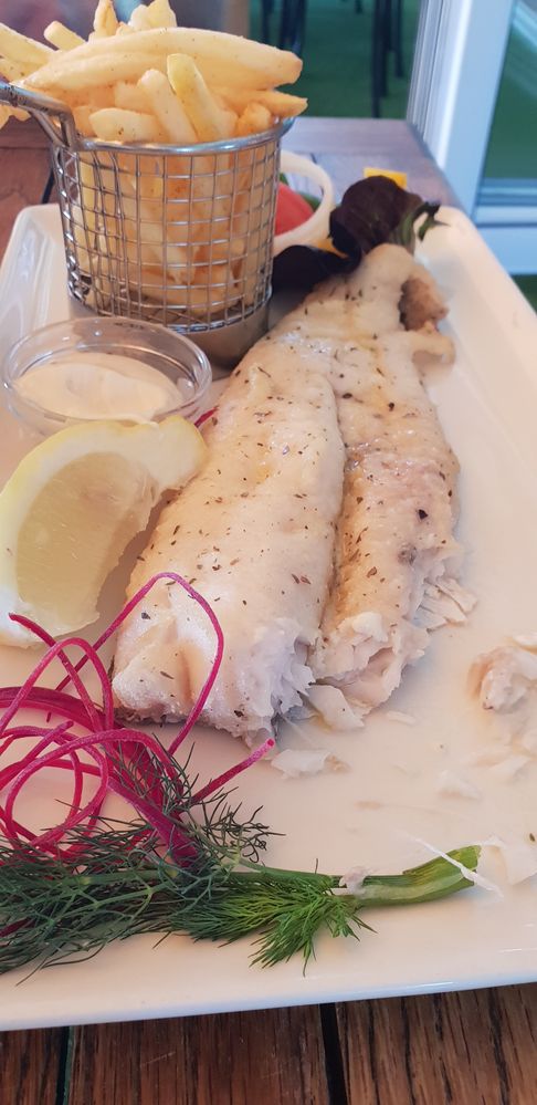 Caption: Grilled hake on a plate served with a side of chips. ( Local Guide AlexaAC)