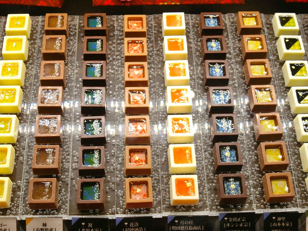 Caption: A photo of several rows of colorful square chocolates with different fillings and toppings. (Local Guide @YasumiKikuchi)