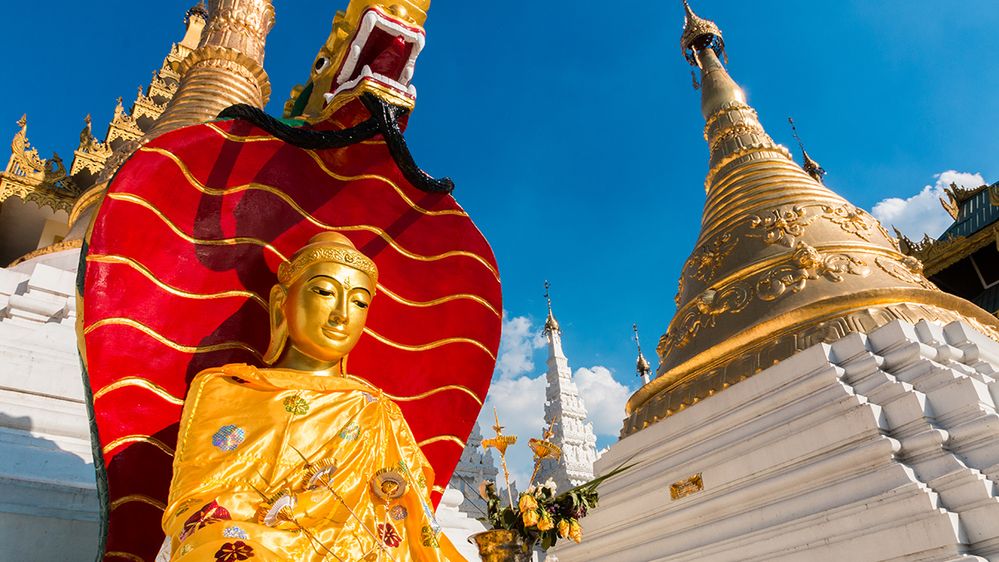 Caption: A photo of a statue and gold plated stupas at Shwedagon Pagoda in Bali, Indonesia. (Local Guide Longatse Michael)