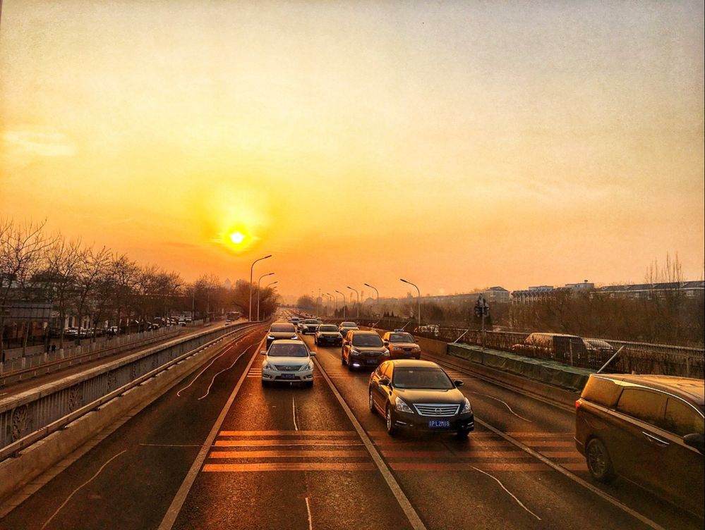Sunset from the back of a bus in Beijing, China. Photo by Penny Christie