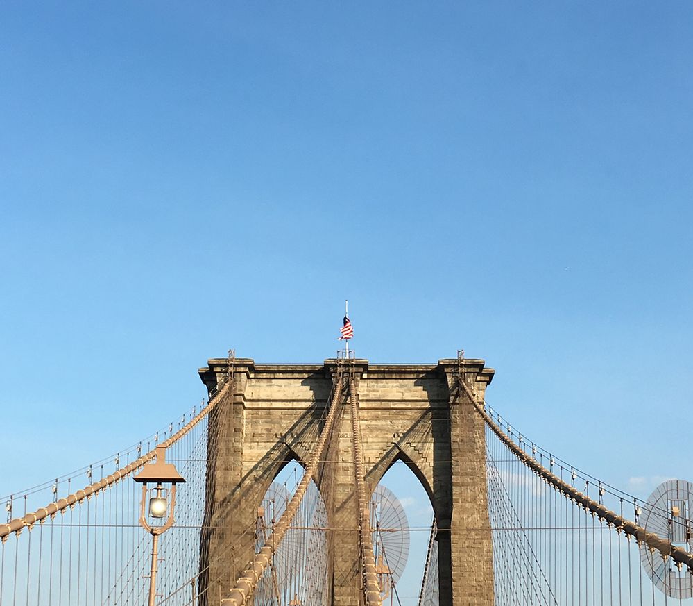 Caption: A photo of the top portion of the Brooklyn Bridge and its cables, with the clear blue sky filling most of the image. Photographed in Brooklyn, New York, New York, USA. (Local Guides Christina-NYC)