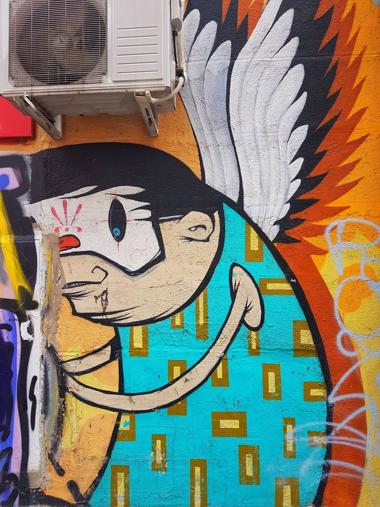 Caption: A photo of a graffiti representing an angel with a mask on his face (Local Guide @InaS)