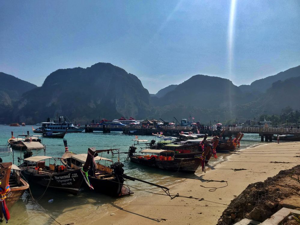 Caption: A photo of Phi Phi Island with boats and ships along the shoreline. (Local Guide @imran1986)
