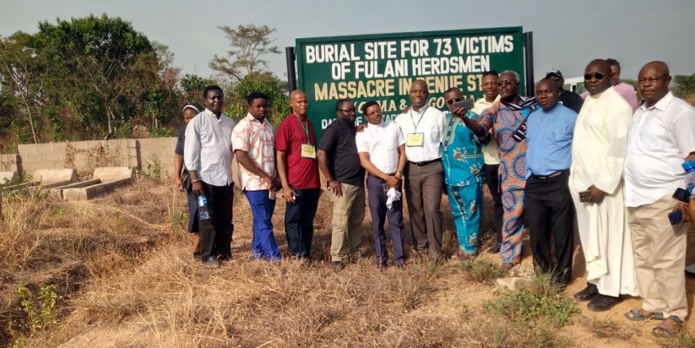 Group photograph at the burial site of the 73 victims