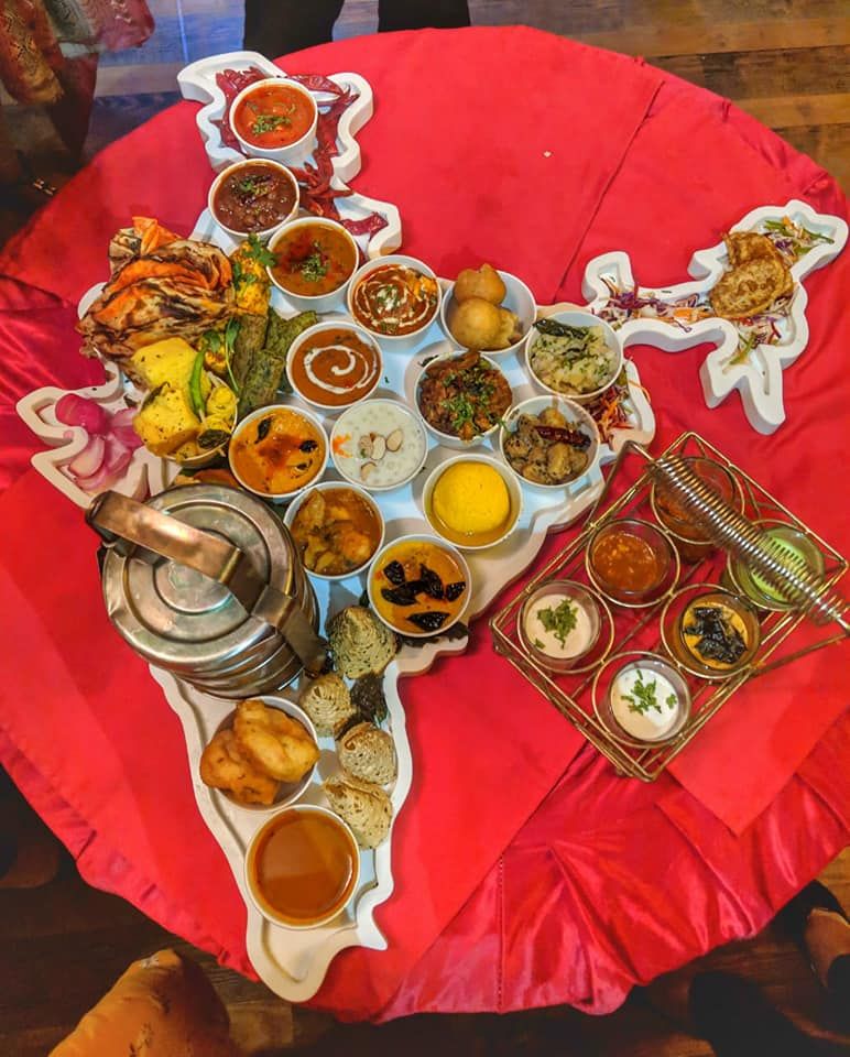 Picture of Great Indian Election Thali representing food from 28 states. The tiffin box has some parathas and biriyani rice!