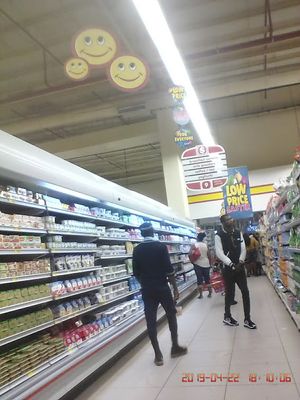 Caption: Photo of customers checking goods displayed at the counter with  an over banner inscribed with low price. Affordability is another key word at the Abia shopping mall