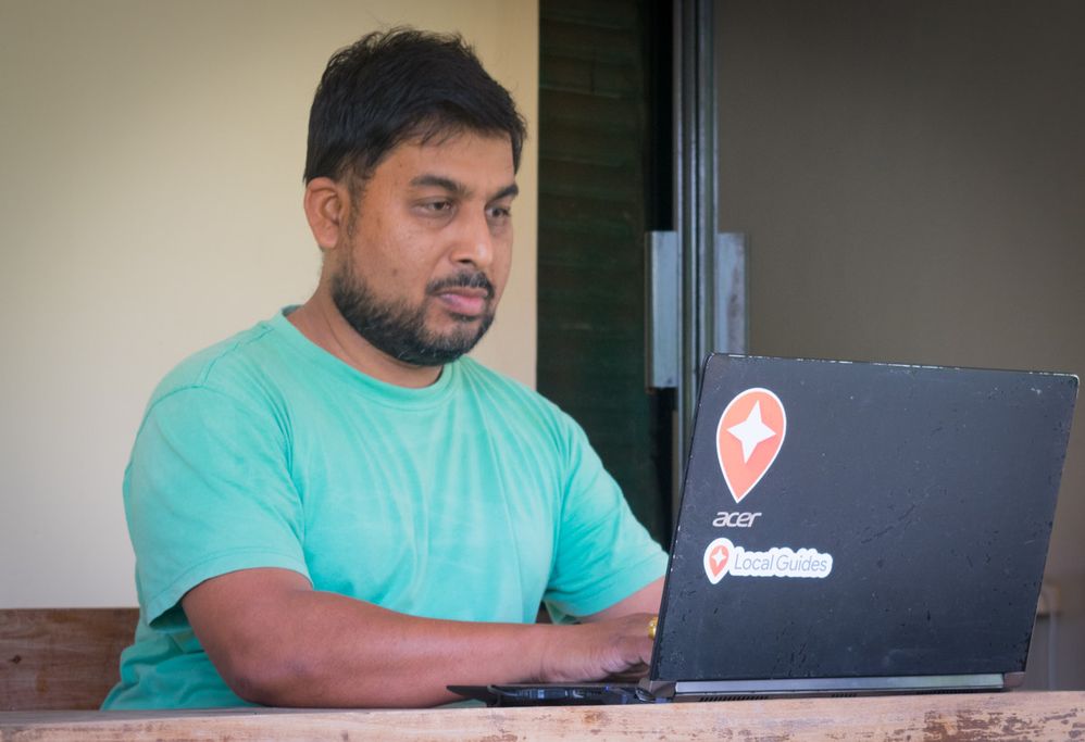 Anuradha Piyadasa and his laptop with Local Guides Stickers....