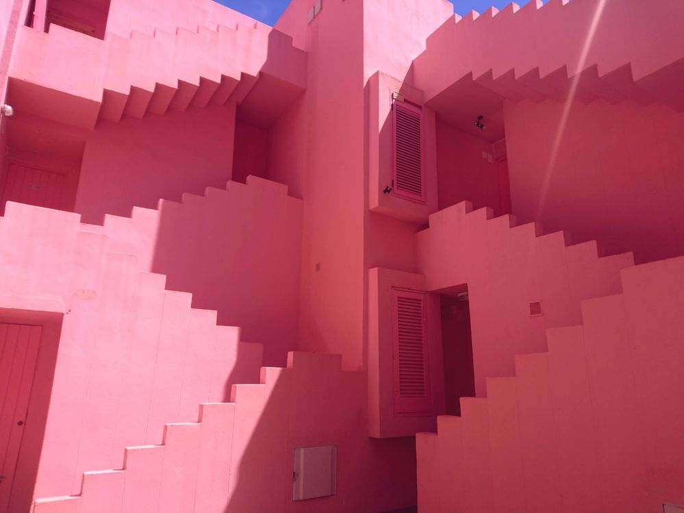 Caption: A photo of the outside stairs of the pink colored Muralla Roja apartment complex in Calpe, Spain. (Local Guide Cata Ionescu)