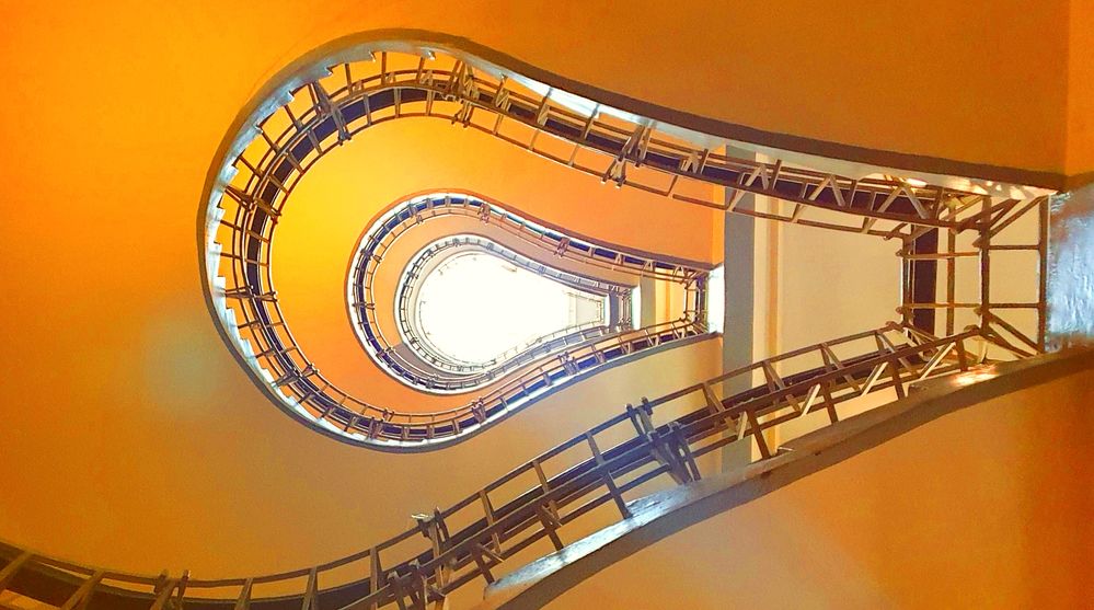 Caption: A photo from below of a staircase that forms a light bulb-like shape at the Grand Café Orient in Prague, Czech Republic. (Local Guide Yves Laudelout)