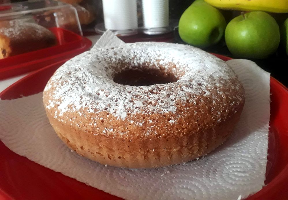 Caption: A photo of homemade round lemon cake with a hole in the middle, sprinkled with powdered sugar. (Local Guide @MoniDi)