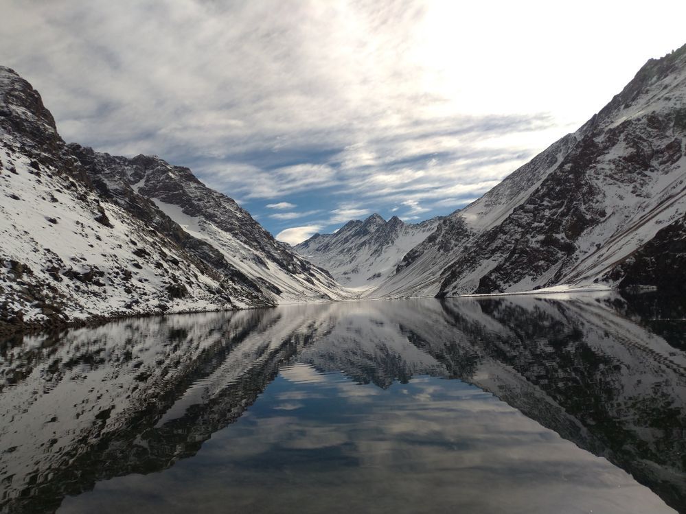 Caption: A photo of the spectacular snowy mountains of The Andes, reflected in a lake, close to Portillo, Chile. (Local Guide @alexandradias)