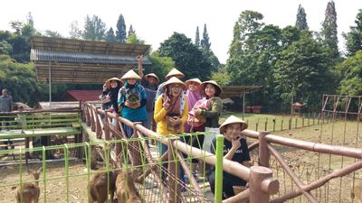 Judul: Beberapa peserta berfoto dengan topi caping dan keranjang sayur di wahanan animal feeding JBound Bogor. Credit: Local Guides Mutiah A