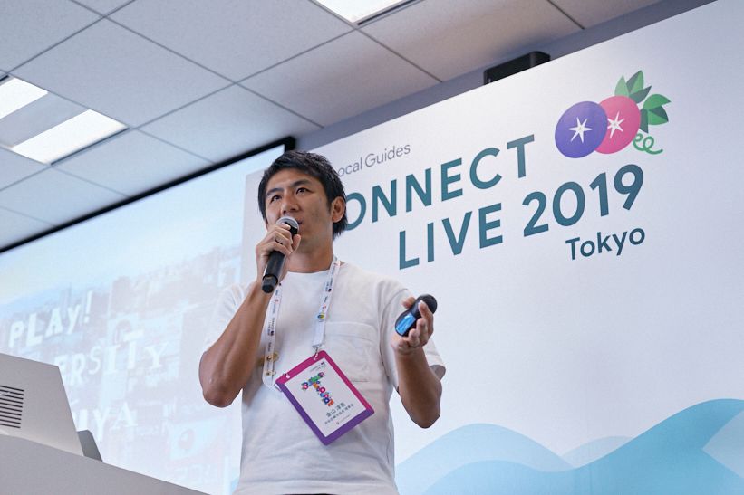 Caption: A photo of the Jungo Kanayama, head of the Shibuya Tourism Board, presenting on-stage at Connect Live Tokyo.