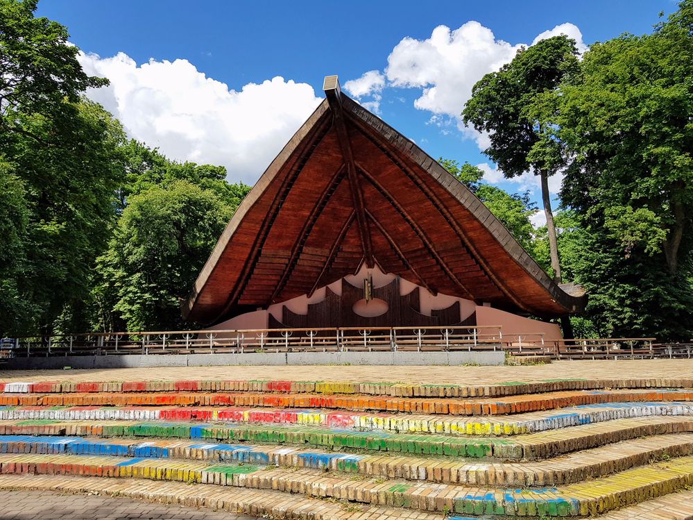 Caption: A view over the summer theatre in Mariinky Park, called  "Rakushka"or" The Seashell" with colorful stairs and magnificent sky behind it (Local Guide @RedCatZs)
