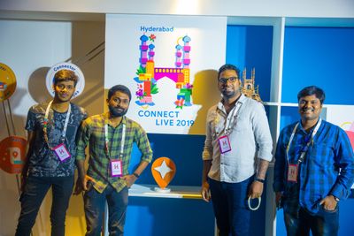 A photo of local guides posing infront of local guide pin and a connect live Hyderabad sign