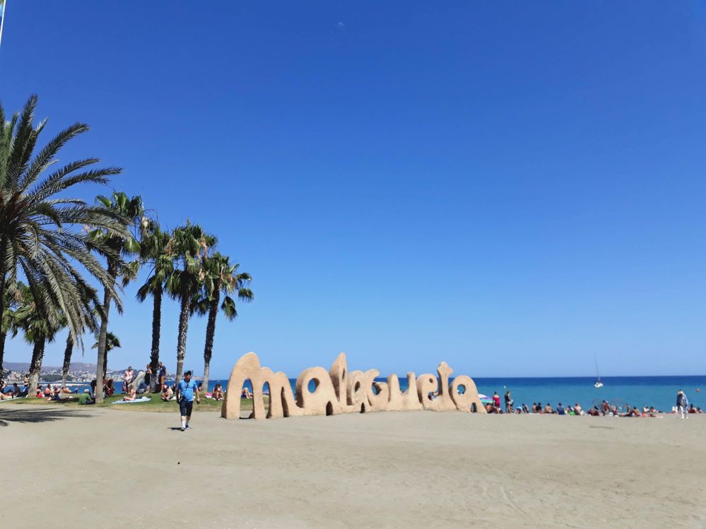 Caption: A photo of the famous 3D sign “Malagueta” at Playa La Malagueta beach, with palm trees on the left side and the sea on the right. (Local Guide @MoniDi)