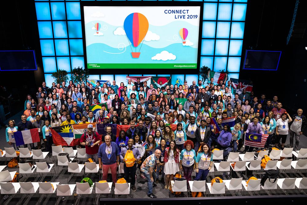 Photo Caption: A photo of attendees in front of the stage with Connect Live on screen from above.