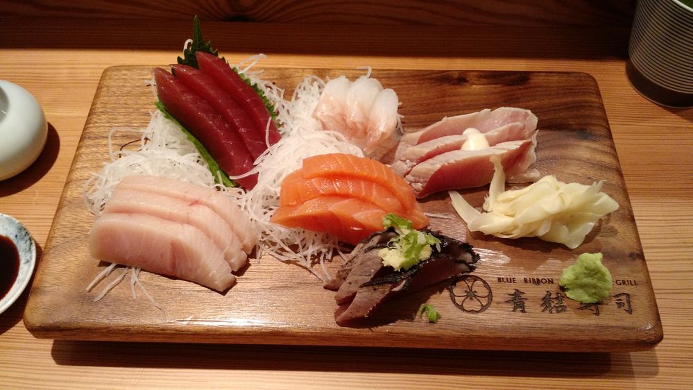 Caption: A photo of an assortment of sashimi on a wooden plate at Blue Ribbon Sushi Bar and Grill in New York, NY. (Local Guide Pedro H.)