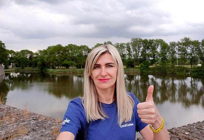 Caption: A both of Jane giving the thumbs up in front of a lake.