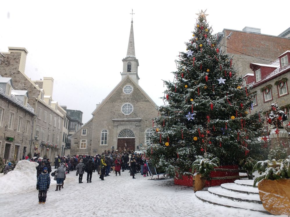 Caption: A photo of a large Christmas tree and several people walking through the snow in front of Notre-Dames-des-Victoires in Quebec City, Quebec, Canada. (Local Guide Francis Bouvrette)