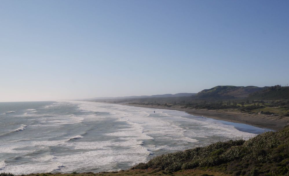 Wide view of other side of Muriwai Beach, ideal for surfing.