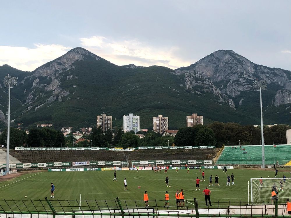 Football players warming up before the match, behind the stadium are  mountain range in Stadion Hristo Botev