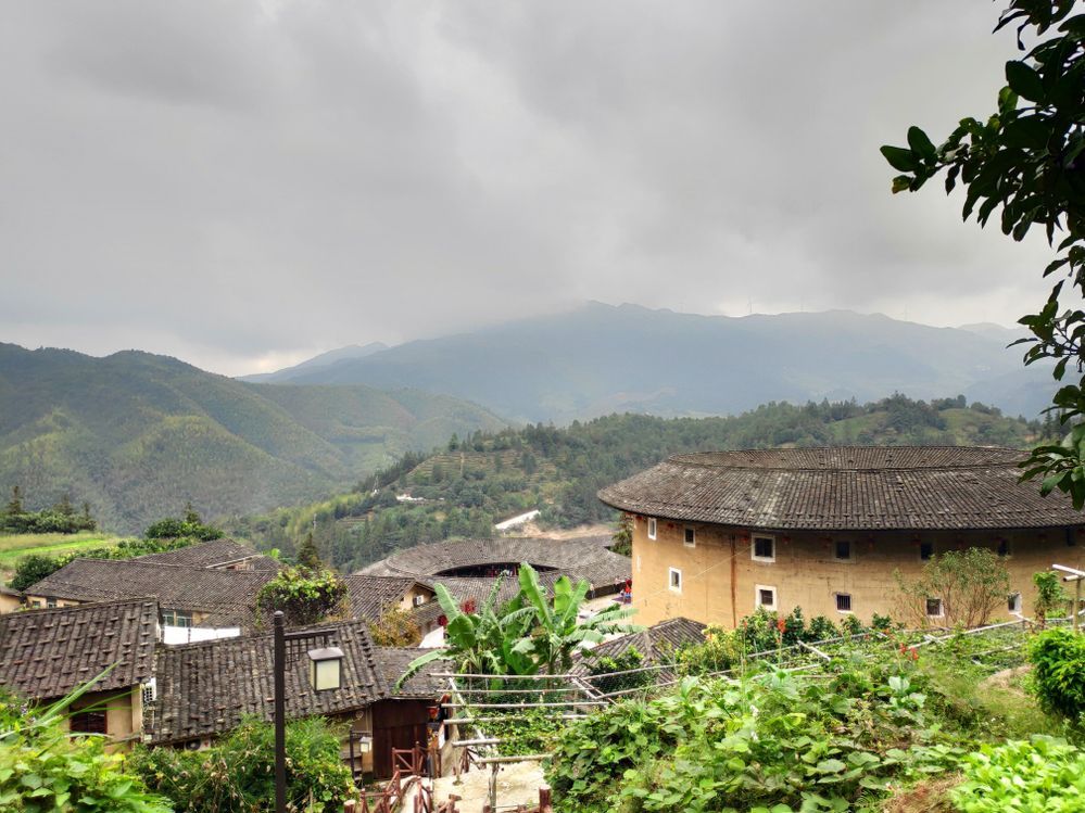 Caption: A panoramic view of traditional tulou earthen houses and green mountains in Fujian Province, China. (Local Guide @nicspelgatti)