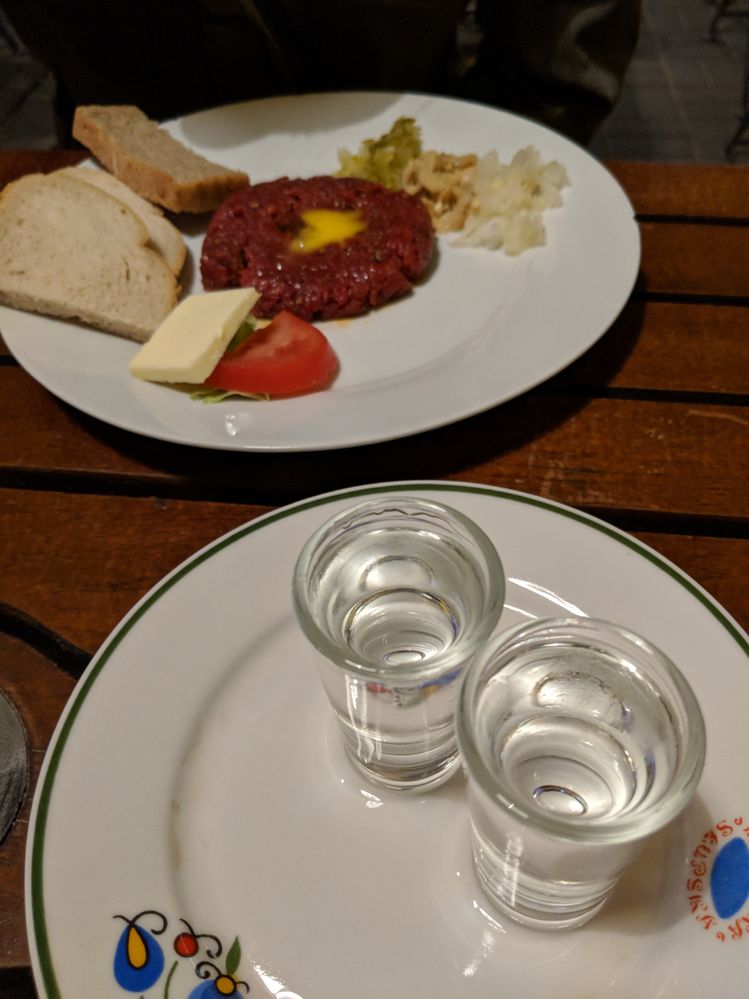 Caption: A photo of two plates, one with two vodka shots and the other with beef tartare with raw egg yolk, bread, and garnish. (Local Guide Paul Kozak)