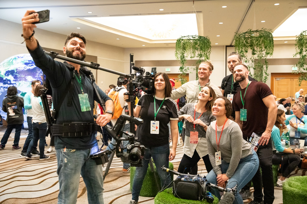 Caption: A photo of the Google Local Guides video team taking a selfie behind their camera equipment at Connect Live 2019 in San Jose, California.