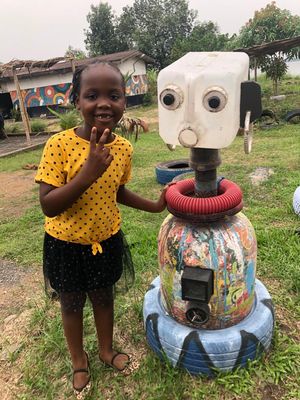 Picture of my girl having fun beside a sculpture made of recycle objets