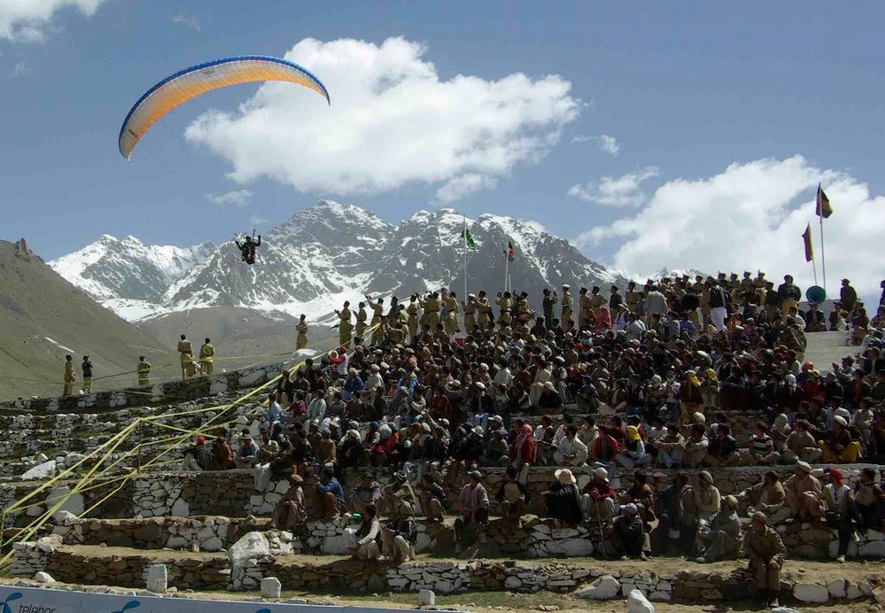 The crowed is amazed by the landing para glider