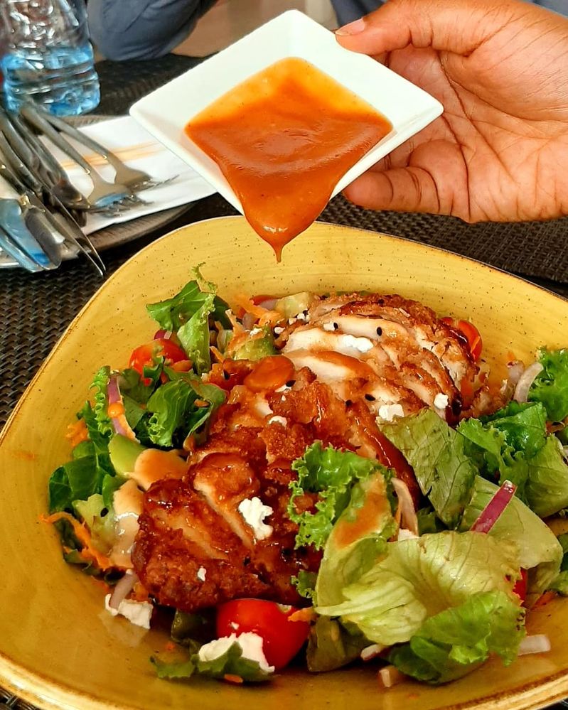 Caption: Honey Sriracha sauce on Crispy Chicken salad from the Pavillion, Abuja captured by Local Guide @Zino_