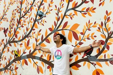 A local guide poses with a wall mural at Block 15 of Lodhi Art District