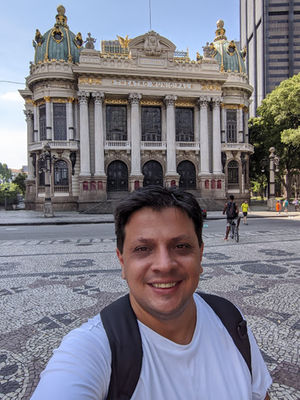 Caption: A photo of Alexandre in front of a building.