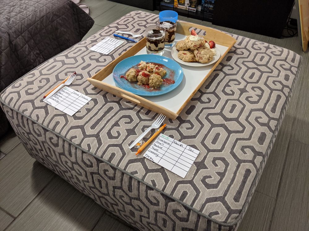 Desserts plated and on a tray with scorecards on an ottoman