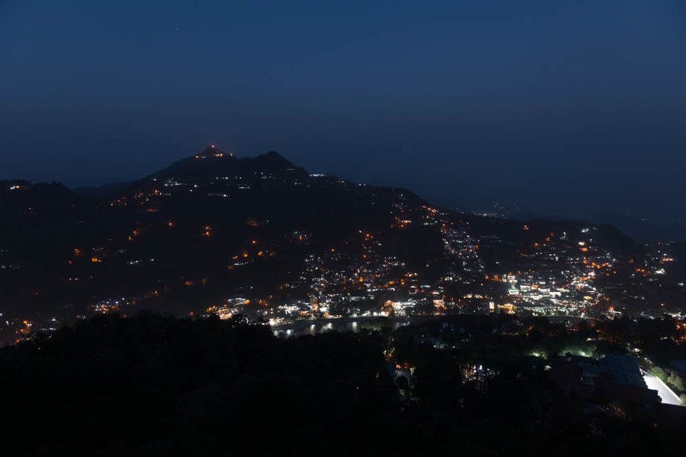 The town of Nainital at Night with the ligts shining off the lake water right at the bottom of the mountain