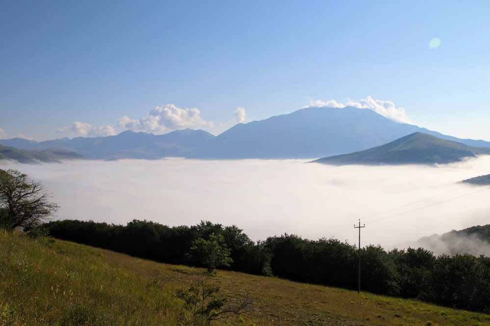 Castelluccio di Norcia valley full covered by early morning fog, photo took from the street going down into the valley - Local guide @LuigiZ