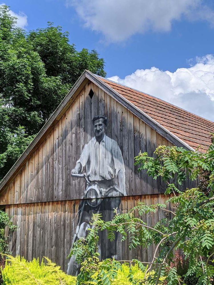 Painting on the barn that shows a man on his motorcycle.