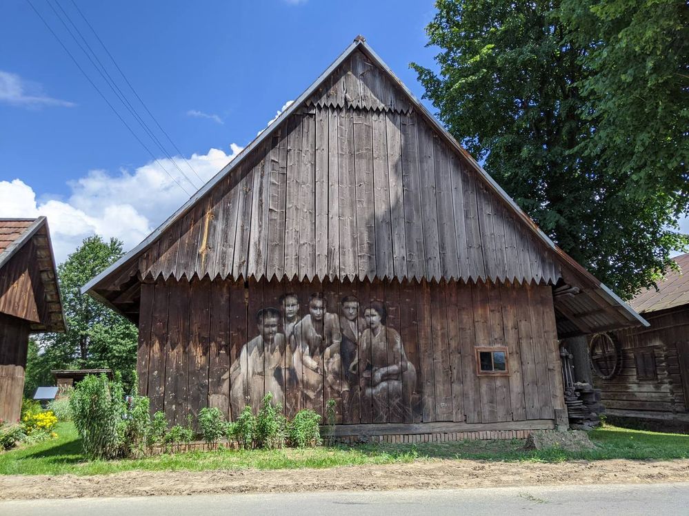 Mural on the wooden barn showing a group on women.